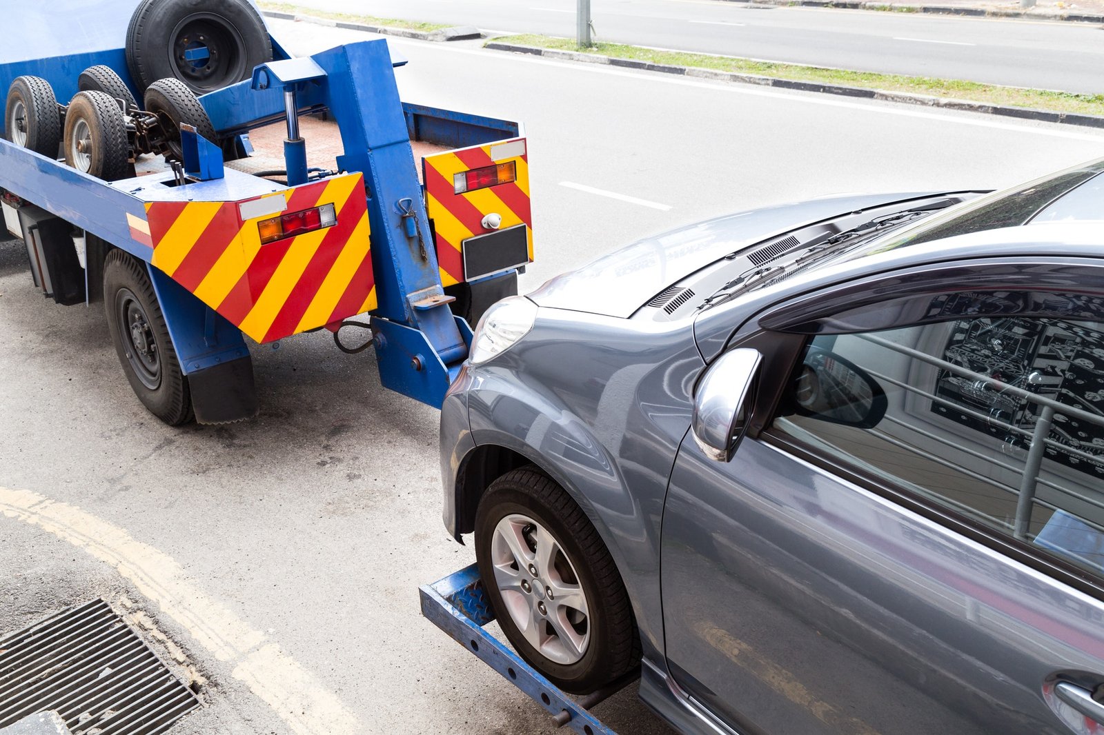 tow-truck-towing-a-broken-down-car-on-the-street
